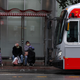 People wear masks as they wait in a bus shelter for a San Francisco MUNI bus amid the coronavirus pandemic.